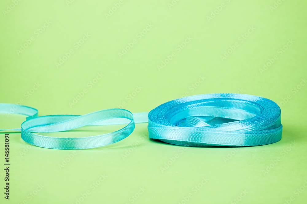 Closeup of ribbon roll over colorful background Closeup of ribbon roll over colorful background