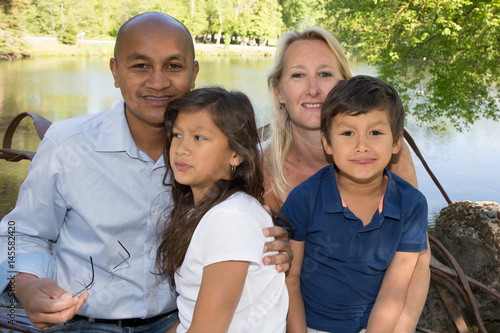 Beautiful multiracial families on the lake with parents and two children