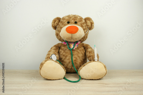 Toy bear with stethoscope and syringe / pediatrician