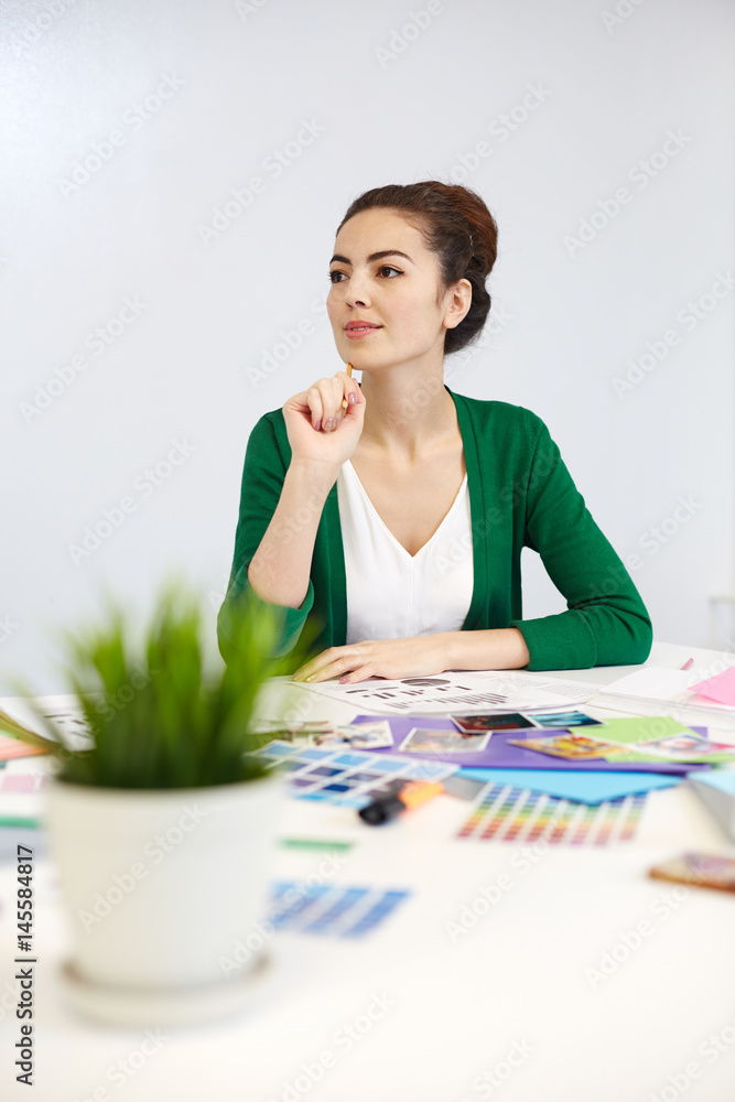Pensive designer thinking of new ideas by workplace Pensive designer thinking of new ideas by workplace