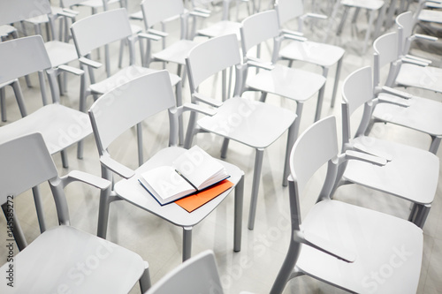 Open notebook with empty pages on white plastic chair