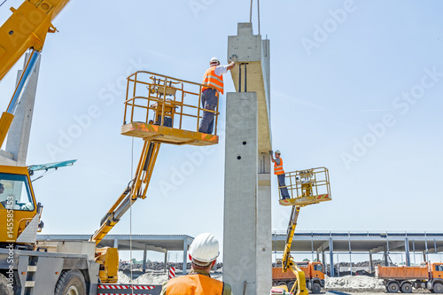 High elevated cherry picker with people who are working in heavy duty photo