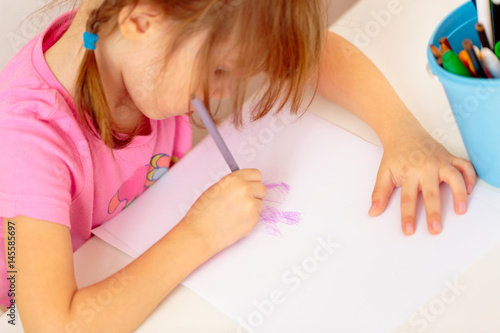 Small girl drawing with colourful pencils