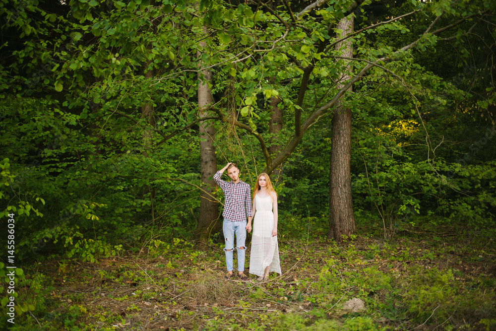 Beautiful Love story in the woods. Portrait of young stylish couple.