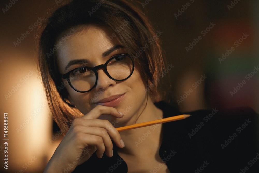 Concentrated young lady designer holding pencil. Concentrated young lady designer holding pencil.
