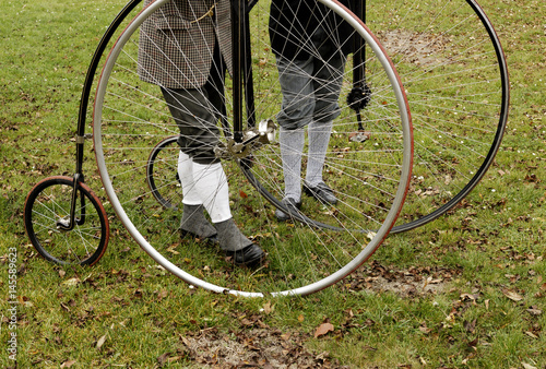 Billede på lærred An unidentified men with a penny-farthing bicycle in a park with fallen autumn l