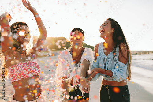 Happy young female friends enjoying party on the beach photo