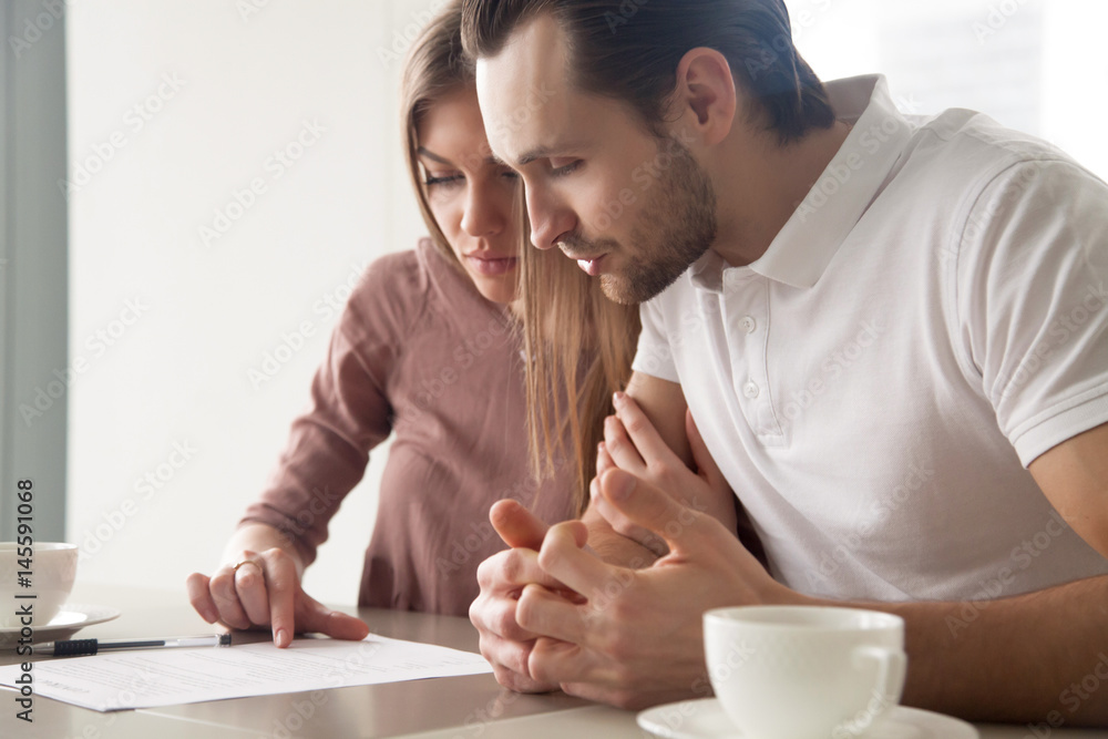© fizkes - Serious couple studying contract agreement, reading terms and conditions attentively before signing, husband and wife calculating domestic bills, considering mortgage loan offer, health insurance © fizkes - Serious couple studying contract agreement, reading terms and conditions attentively before signing, husband and wife calculating domestic bills, considering mortgage loan offer, health insurance
