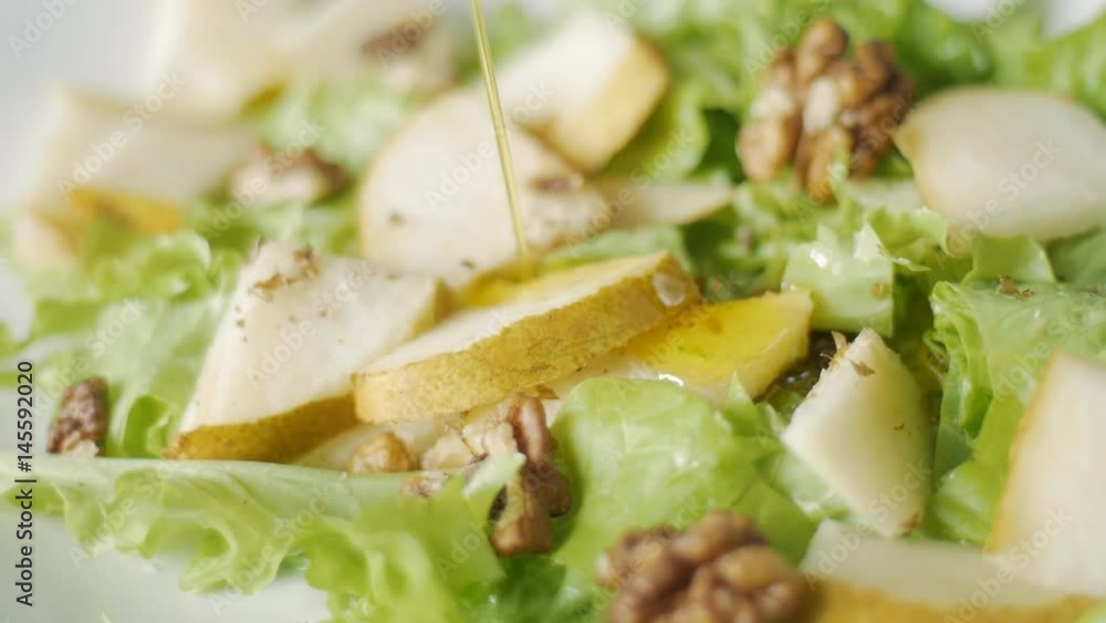 Close up of dressing fresh salad with olive oil at home - healthy eating, vegetarian food, dieting and people concept Close up of dressing fresh salad with olive oil at home - healthy eating, vegetarian food, dieting and people concept