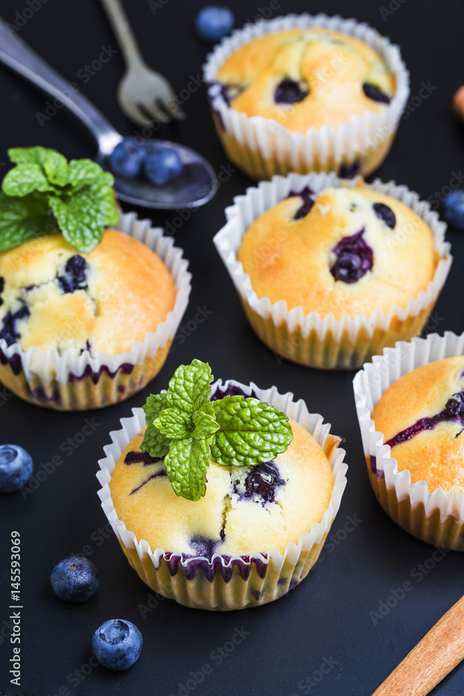 Blueberry muffins with powdered sugar and fresh berries Blueberry muffins with powdered sugar and fresh berries