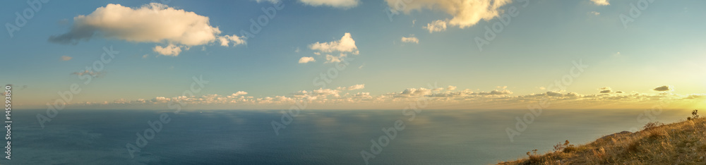 Amazing wide panoramic mountain view on the sea with the nice blue sky and little light clouds in the warm sun light before sunset in Crimea, Ukraine Amazing wide panoramic mountain view on the sea with the nice blue sky and little light clouds in the warm sun light before sunset in Crimea, Ukraine