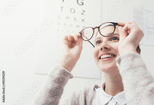 Fototapeta Naklejka Na Ścianę i Meble -  Happy woman trying her new glasses