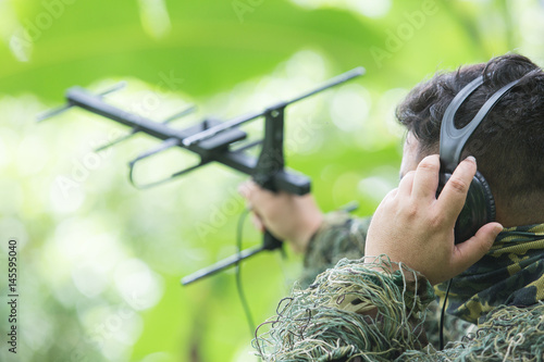 rnithologist take antenna and earphone for tracking animal movement in forest for research