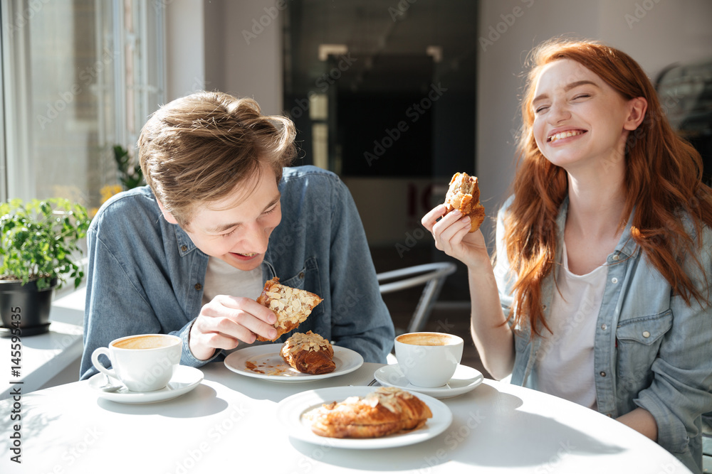 Man and woman eating desserts in cafe