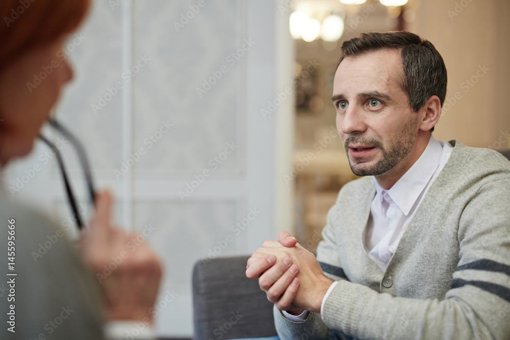 Fototapeta premium Anxious man telling his story to psychologist