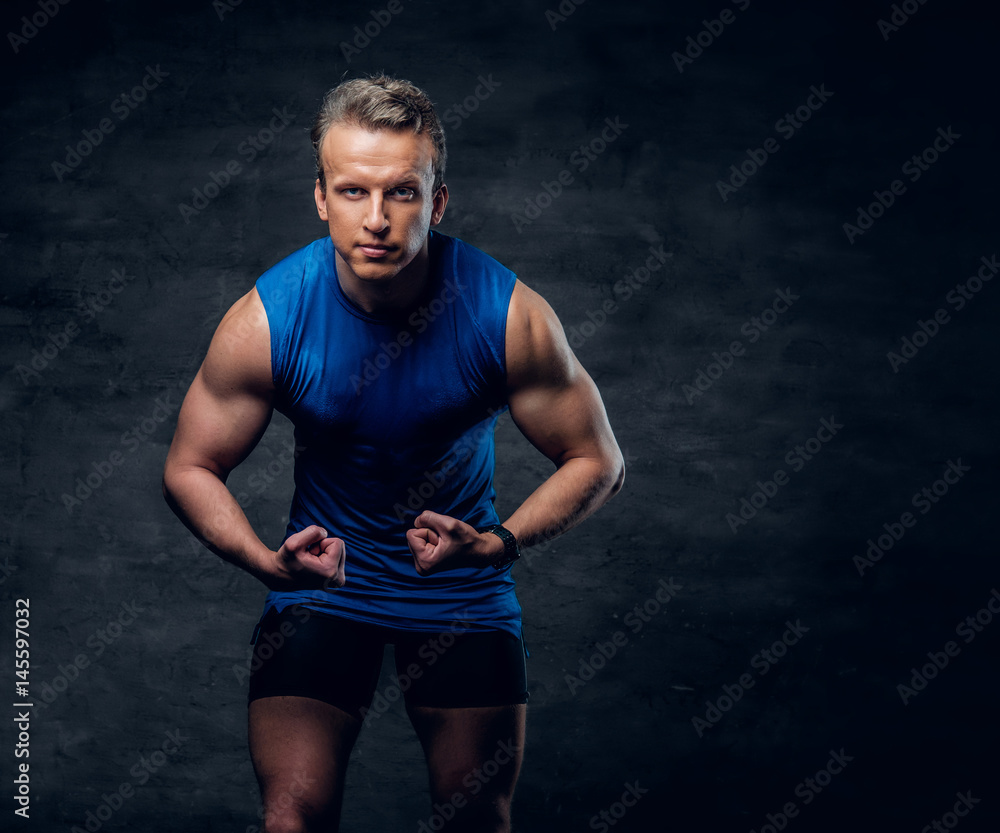 Fototapeta premium Portrait of attractive sporty male dressed in a blue sportswear.