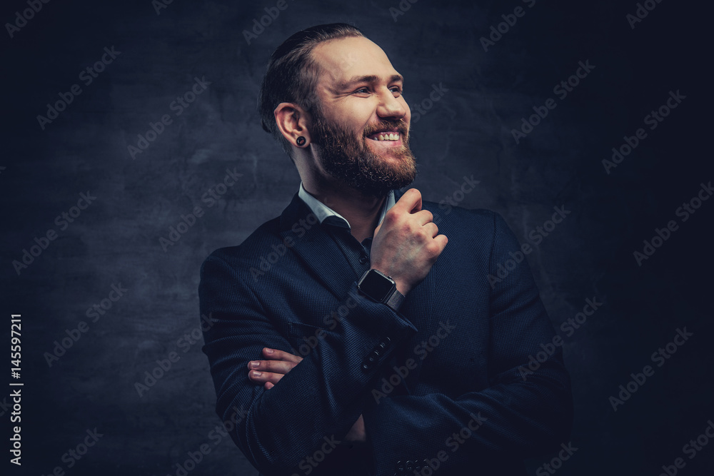 Bearded male dressed in a blue jacket over grey vignette background.