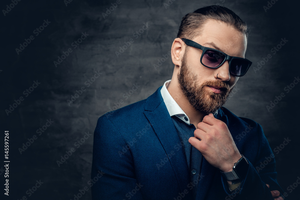 Fototapeta premium Stylish bearded male in sunglasses over dark grey background.