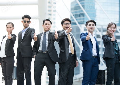 Successful business people with thumbs up and smiling