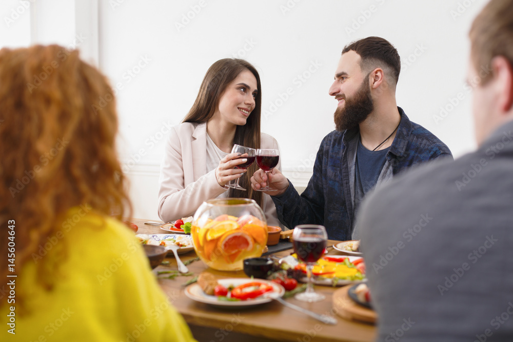 Group of happy young people at dinner table, friends party