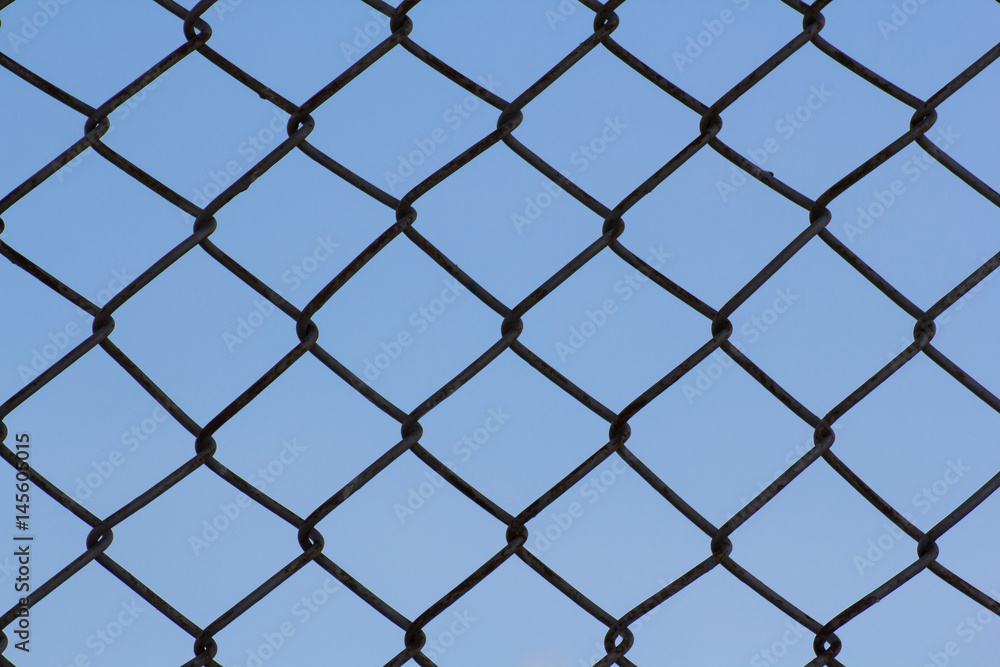 black wire fence and blue sky background black wire fence and blue sky background