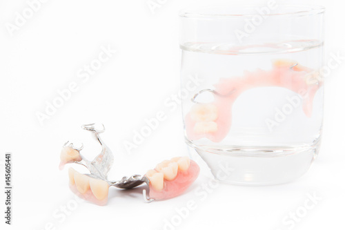 denture is cleaned in a glass of water. proper hygiene.