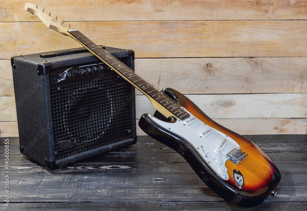 Obraz premium Electric guitar with amplifier on wooden planks