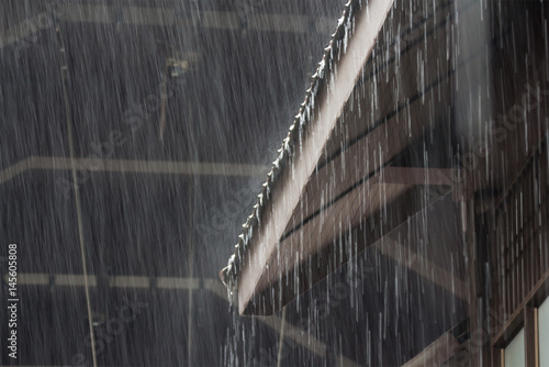 Vászonkép heavy rain on roof of wooden house, rainy season