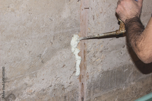 Builder foam fills the cracks in the concrete wall