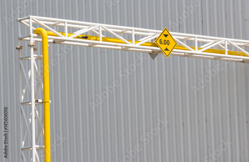 Canvas Print Height Restriction limit Sign on pipe rack, yellow metal sign on steel structure