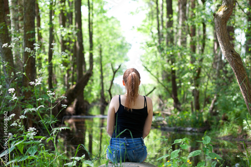 молодая девушка на берегу реки в лесу