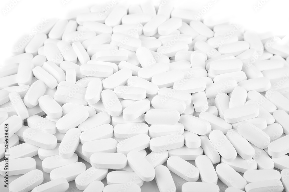 White calcium pills on a white surface. Vitamins isolated on white background. White calcium pills on a white surface. Vitamins isolated on white background.