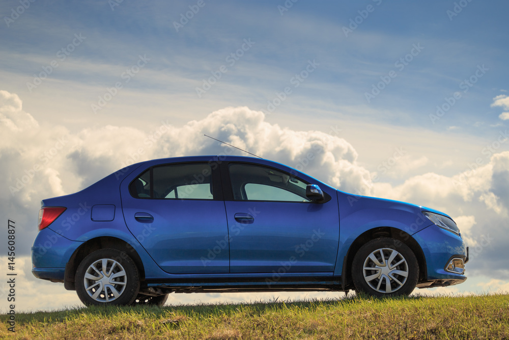 Fototapeta premium GOMEL, BELARUS - 16 April 2017: Beautiful blue car against the sky with clouds