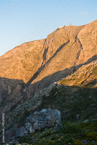 Prophet Ilias mountain and monastery at sunsrise, highest point of Santorini island, Greece