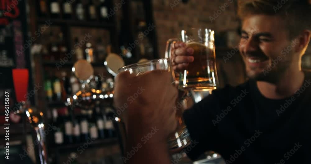 Two happy male friends toasting a glasses of beer Two happy male friends toasting a glasses of beer