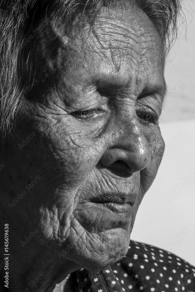Obraz premium Lonely senior woman portrait sad depressed,emotion, feelings, thoughtful, senior, old woman,wait, gloomy, worried, covering her face, Human face expressions, isolated black background