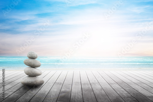 Stack of pebble stones at the beach on a wooden surface. Concept Zen, Spa, Summer, Beach, Sea, Relax.