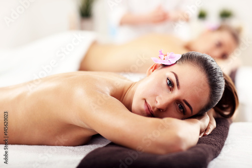 Two beautiful women getting massage in spa