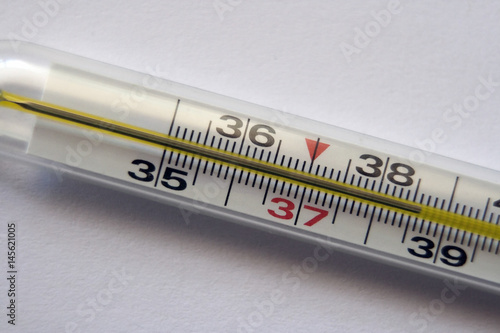 Thermometer with a high body temperature: 38.6 degrees Celsius. Close-up on a white background