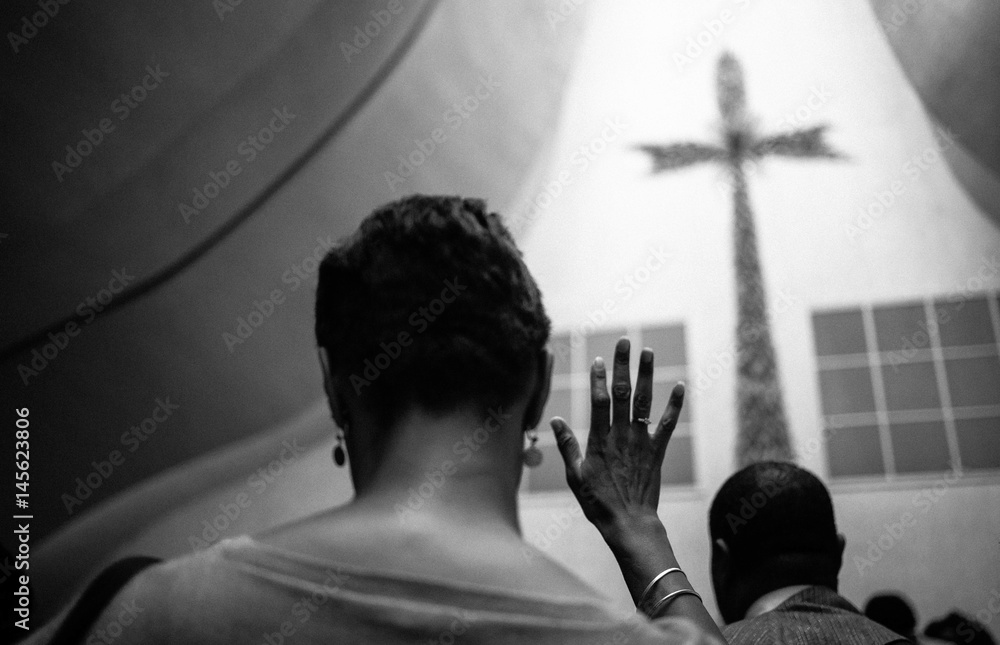 Obraz premium A black woman crosses her fingers in the church. 