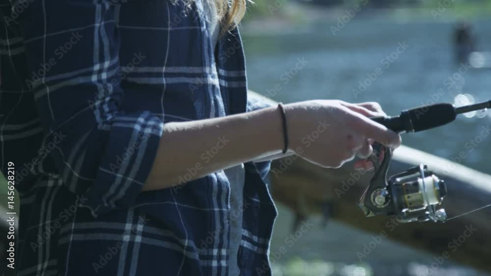 Girl reeling in fishing line while fishing