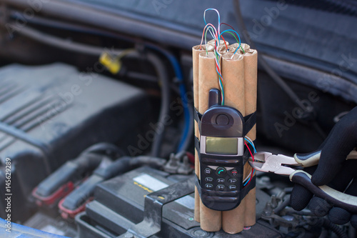 A bomb under the hood near the engine of the car. Explosive with a detonator  is a mobile phone in the car. Mine Clearance or demining Stock Photo |  Adobe Stock