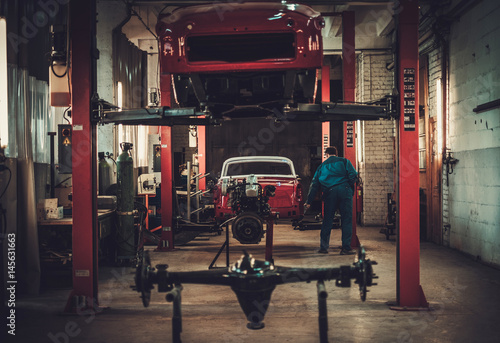 Mechanic in classic car restoration workshop