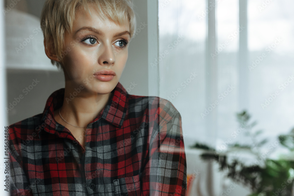 Young woman standing near window Young woman standing near window