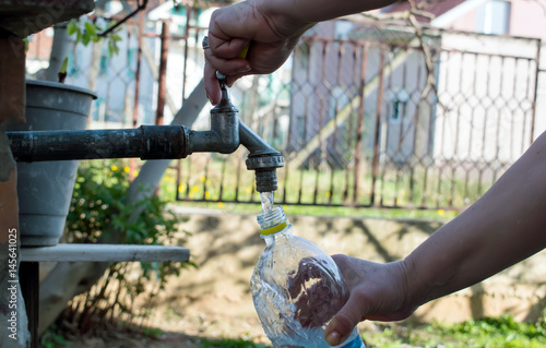woman hand pouring water in a plastic bottle