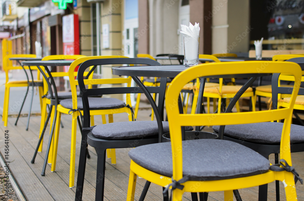Close up of a small street cafe exterior in yellow and grey tones