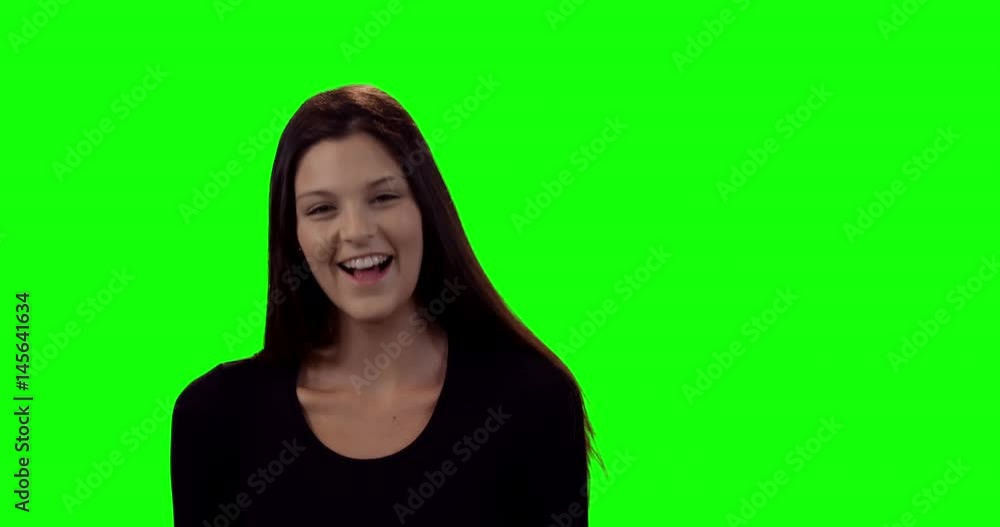 Smiling beautiful woman standing against green screen Smiling beautiful woman standing against green screen