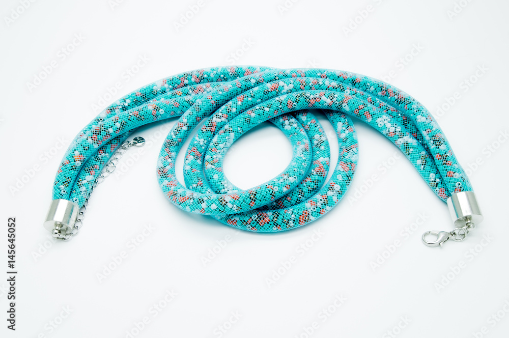 on a white background lies a necklace on the neck with a blue gem on a white background lies a necklace on the neck with a blue gem