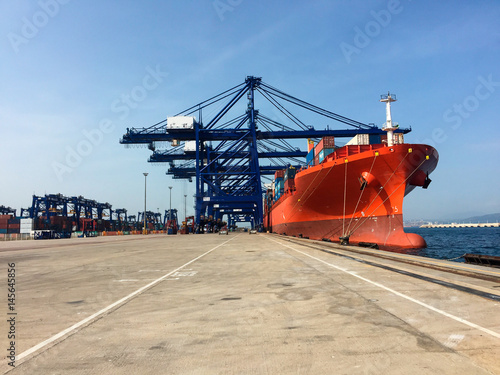Cranes of dockers loading boat with containers in Algeciras port