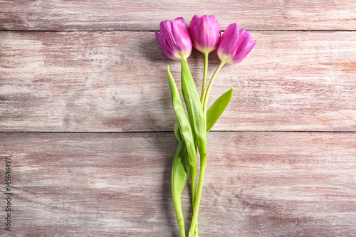 Beautiful lilac tulips on wooden background